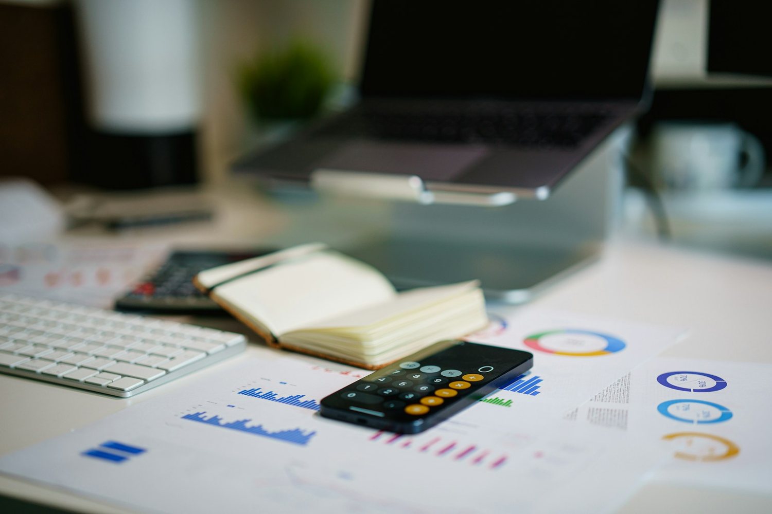 Financial analysis desk with printed charts, calculator and financial reports